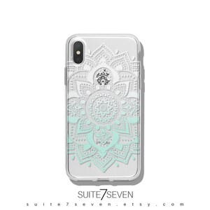 May include: A clear phone case with a white and light blue mandala design. The design is a gradient, with the white at the top and the light blue at the bottom. The case is for an iPhone.