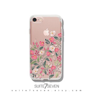 Puede incluir: Una funda transparente para tel&eacute;fono con un dise&ntilde;o floral con flores rosas y blancas y hojas verdes. La funda est&aacute; dise&ntilde;ada para un iPhone 7.
