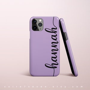 May include: A lavender phone case with a black cursive name "Hannah" printed on the side. The case is shown with the phone inside and the case is also shown separately.