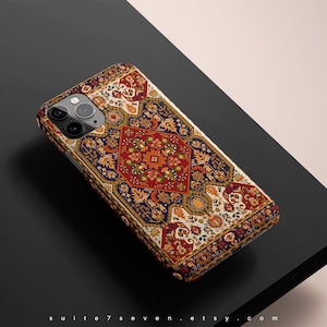 May include: A phone case with a colorful, intricate pattern reminiscent of a Persian rug. The case features a geometric design with red, blue, and gold accents.