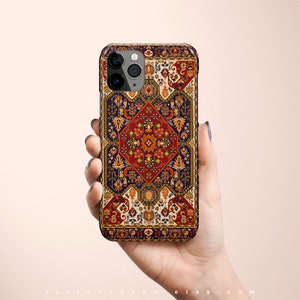 May include: A phone case with a colorful, intricate design inspired by a traditional rug. The case features a repeating pattern of geometric shapes and floral motifs in shades of red, orange, yellow, blue, and green.