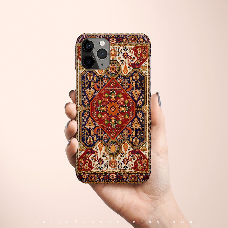 May include: A phone case with a colorful, intricate design inspired by a traditional rug. The case features a repeating pattern of geometric shapes and floral motifs in shades of red, orange, yellow, blue, and green.