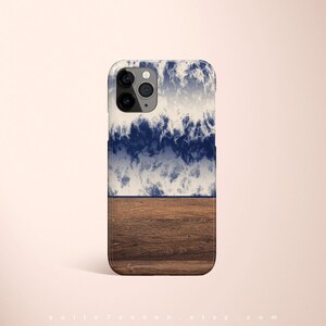 May include: A phone case with a blue and white wave design and a brown wood grain pattern on the bottom half.