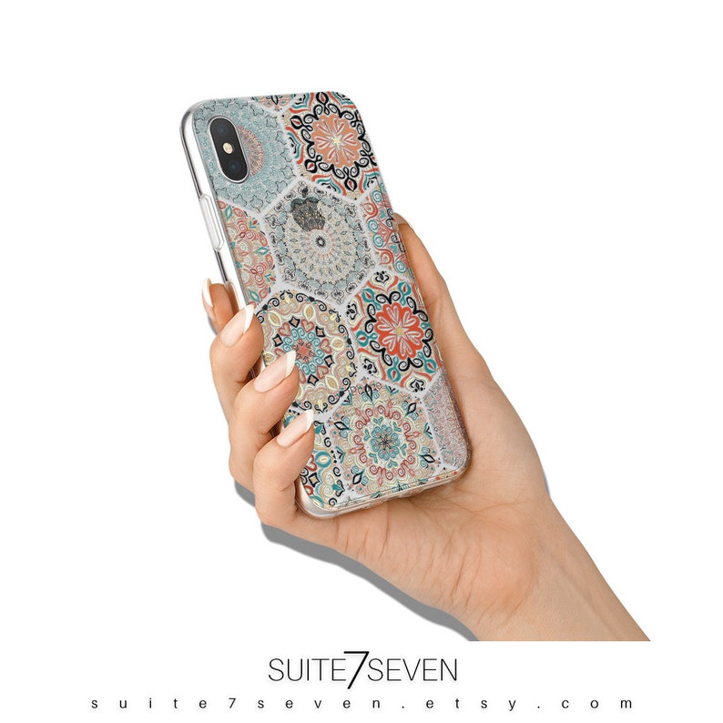 May include: A clear phone case with a colorful geometric pattern. The pattern features hexagonal tiles with intricate designs in shades of blue, green, orange, and white.