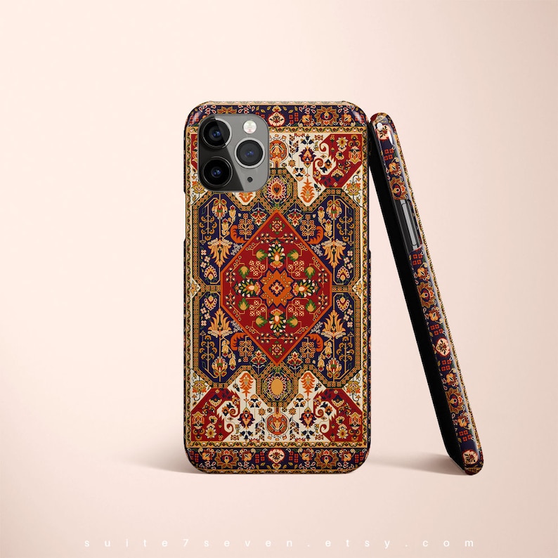 May include: A phone case with a colorful, intricate design inspired by a traditional Persian rug. The case features a central diamond shape with floral motifs and a border of geometric patterns. The case is made of durable plastic and is compatible with most smartphones.