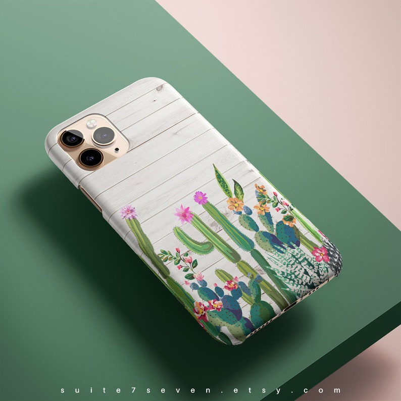 May include: A white woodgrain phone case with a colorful cactus design. The case has a cutout for the camera lens.