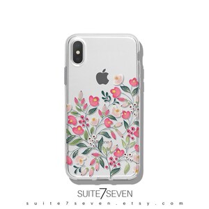 Puede incluir: Una funda transparente para tel&eacute;fono con un dise&ntilde;o floral que presenta flores rosas y blancas, hojas verdes y bayas rojas. La funda es compatible con iPhone X.