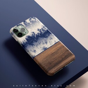 May include: A phone case with a blue and white cloud design on the top half and a brown wood grain design on the bottom half.