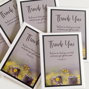 Może przedstawiać: Kolekcja kartek z podziękowaniami z kwiatowym tłem. Każda karta ma szare tło ze słowami "Thank You" elegancką czcionką. Karty zawierają również werset biblijny.