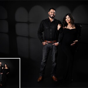 Peut inclure: Un couple pose pour une photo dans un studio sombre avec un fond de fen&ecirc;tre ombrag&eacute;. L'homme porte une chemise boutonn&eacute;e noire et un jean. La femme porte une robe noire et a de longs cheveux noirs.