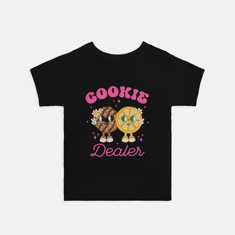 May include: Black t-shirt with a pink graphic of a cookie and a lemon slice holding hands. The text "Cookie Dealer" is written in pink below the graphic.