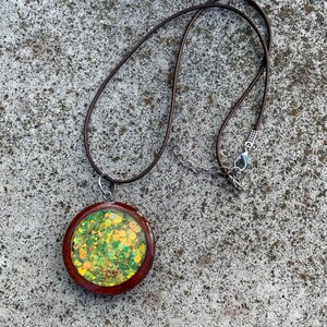 Collar con colgante de bisel abierto de corazón inclinado de madera negra con polvo de repujado de brillo rojo y resina UV