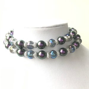 May include: A double strand necklace featuring iridescent black pearls and clear and blue crystal beads.