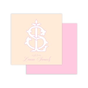 May include: A light peach-colored gift tag with a pink monogram and the words "a gift from Laura Samuels." A pink card is visible beneath the gift tag. The monogram features the letters "S" and "L".