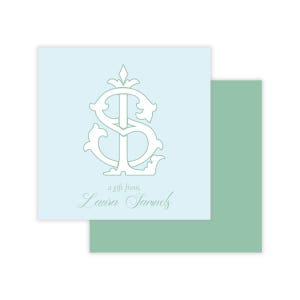May include: A light blue gift tag with a stylized monogram in white, along with the text "a gift from, Laura Samuels". A second, sage green tag is partially visible behind the first.