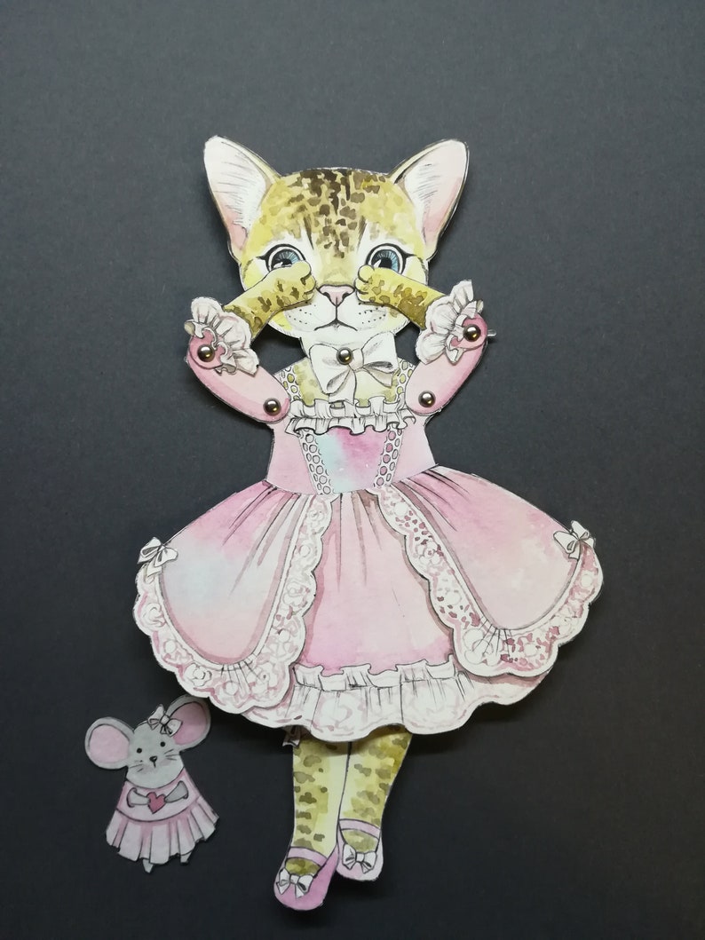 May include: A paper doll of a cat wearing a pink dress with lace trim and a bow. The cat is covering its eyes with its paws. A small paper doll of a mouse wearing a pink dress is standing next to the cat.