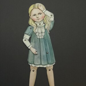 May include: A paper doll illustration of a young girl with blonde hair, wearing a teal dress with a white ruffled collar. The doll has articulated joints and is set against a dark gray background. The girl is holding her hand to her forehead.