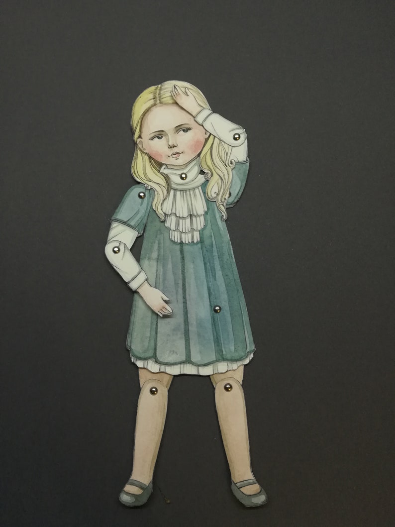 May include: A paper doll illustration of a young girl with blonde hair, wearing a teal dress with a white ruffled collar. The doll has articulated joints and is set against a dark gray background. The girl is holding her hand to her forehead.