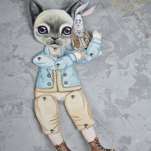 Puede incluir: Una mu&ntilde;eca de papel caprichosa con un gato y un conejo como compa&ntilde;eros. La mu&ntilde;eca gato lleva una chaqueta azul claro, pantalones color beige y botas marrones. El conejo lleva un traje marr&oacute;n. La mu&ntilde;eca est&aacute; articulada con cierres met&aacute;licos.