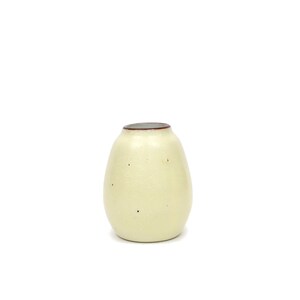 May include: A small, off-white ceramic vase with a brown rim. The vase has a speckled texture and an oval shape.