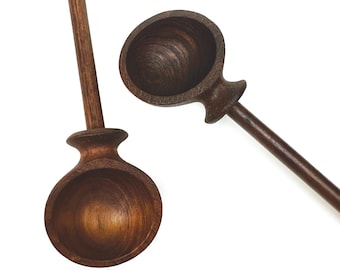 May include: Two wooden scoops with long handles. The scoops are dark brown and have a rounded bowl shape.