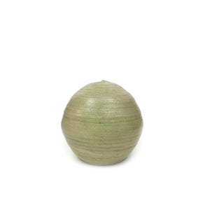 May include: A round, green ceramic vase with a textured surface.