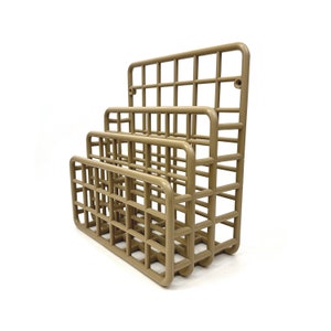 May include: A three-tiered brown plastic magazine rack with a grid pattern. The rack is made of sturdy plastic and has a modern design.