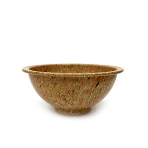 Puede incluir: Un cuenco moteado de color canela con un borde redondeado y una base de pedestal. El cuenco tiene un patrón moteado con motas rojas y negras. El cuenco está hecho de un material duradero.