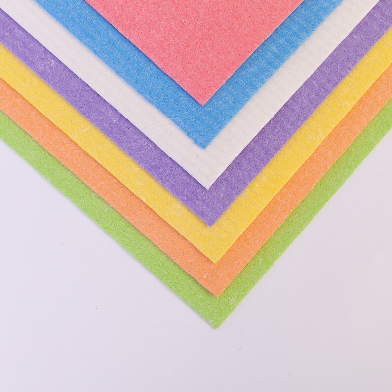 May include: A stack of colorful microfiber cloths in shades of green, orange, yellow, purple, white, and blue. The cloths are folded in a triangular shape.