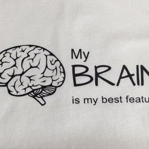 May include: A white t-shirt with a black outline of a brain and the text "My BRAIN is my best feature".