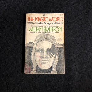 May include: The cover of a paperback book titled "The Magic World: American Indian Songs and Poems" by William Brandon. The cover features a black and white illustration of a Native American man with a horse and rider behind him.