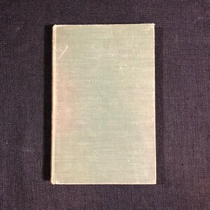 Puede incluir: Un libro de tapa dura de color verde claro liso con una cubierta texturizada.