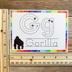 K&ouml;nnte beinhalten: Ein ausdruckbares Arbeitsblatt mit einem Regenbogenrand. Das Arbeitsblatt enth&auml;lt eine Punktierlinie-Spuraktivit&auml;t f&uuml;r den Buchstaben "G" und das Wort "Gorilla". Eine Schwarzwei&szlig;illustration eines Gorillas ist enthalten.