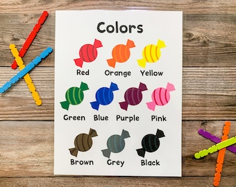 May include: A printable chart with the word "Colors" at the top.  The chart shows candy-shaped illustrations in different colors, with the name of each color written below the illustration.  The colors shown are red, orange, yellow, green, blue, purple, pink, brown, grey, and black.