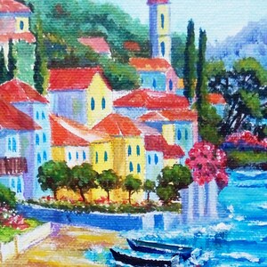 May include: A painting depicting a colourful seaside village with red-tiled roofs, a tall white tower, and two boats in the water. The scene is painted in a bright, impressionistic style.