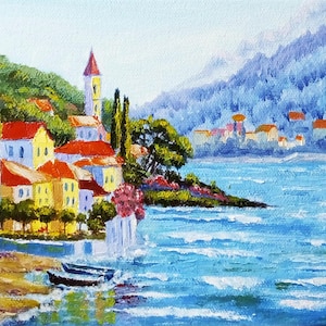 May include: A painting depicting a small town nestled on a hillside overlooking a blue expanse of water. The town features red-roofed buildings and a tall white church spire. The water is choppy and a small boat is visible in the foreground.
