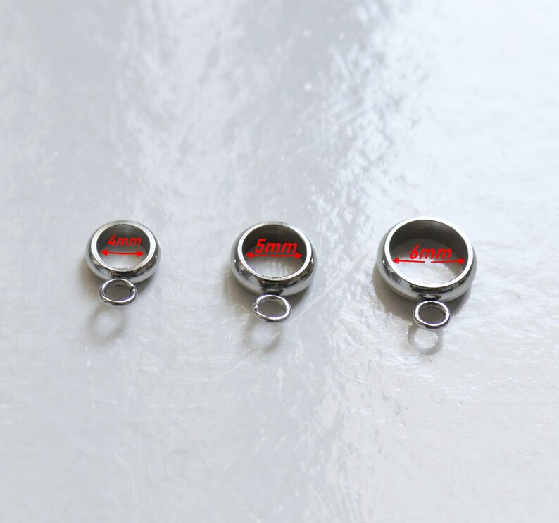 Peut inclure: Trois anneaux de saut en argent avec une boucle en bas. Les anneaux ont un diam&egrave;tre de 4 mm, 5 mm et 6 mm.