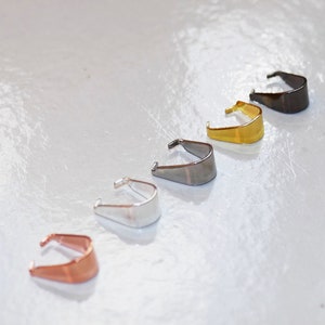 May include: Five different coloured metal jump rings. The rings are in a row from left to right: copper, silver, gunmetal, gold, and black.