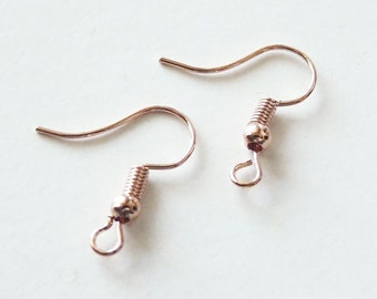 May include: A pair of rose gold earring hooks with a spring closure. The hooks are made of metal and have a smooth finish.