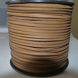 May include: A spool of brown leather cord, wound tightly and ready for crafting projects.