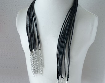 May include: A set of ten black cord necklaces with silver lobster clasps. The necklaces are displayed on a white mannequin.