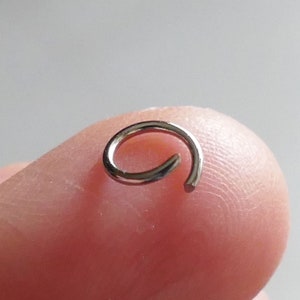 May include: A silver jump ring, a small metal ring used for connecting jewelry components.