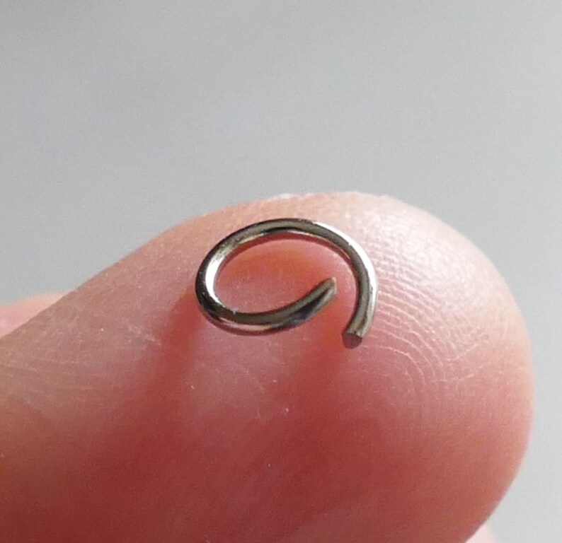 May include: A silver jump ring, a small metal ring used for connecting jewelry components.