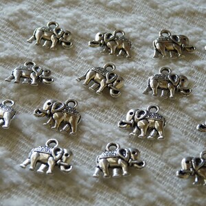 K&ouml;nnte beinhalten: Eine Sammlung von 15 silbernen Elefantenanh&auml;ngern, jeder mit einem detaillierten Design. Die Anh&auml;nger sind perfekt, um Schmuck oder Bastelarbeiten eine Prise Verspieltheit zu verleihen.