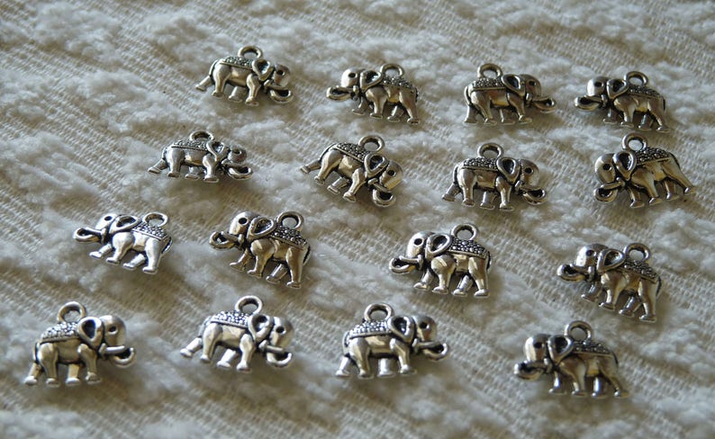 K&ouml;nnte beinhalten: Eine Sammlung von 15 silbernen Elefantenanh&auml;ngern, jeder mit einem detaillierten Design. Die Anh&auml;nger sind perfekt, um Schmuck oder Bastelarbeiten eine Prise Verspieltheit zu verleihen.