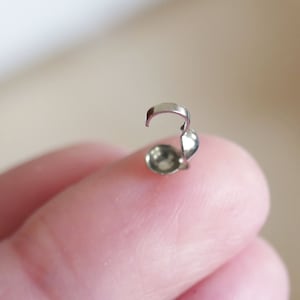 May include: Silver-toned metal bead end cap with a small loop for attaching to jewelry.
