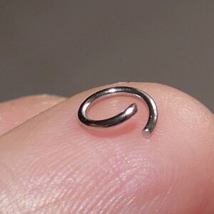 May include: A silver jump ring, a small metal ring used for connecting jewelry components.