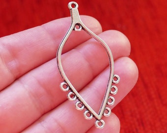 May include: Silver teardrop-shaped pendant with a loop at the top and a series of small circles around the bottom edge.