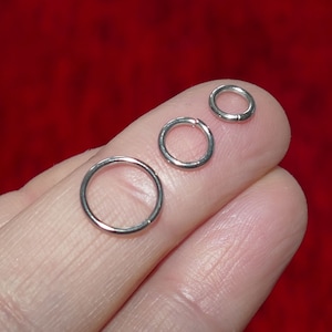 Op de afbeelding: Drie zilveren springringen in verschillende maten. De ringen zijn glad en glanzend.