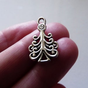 Könnte beinhalten: Silberner Anhänger in Form eines Weihnachtsbaums mit einem Wirbelmuster.